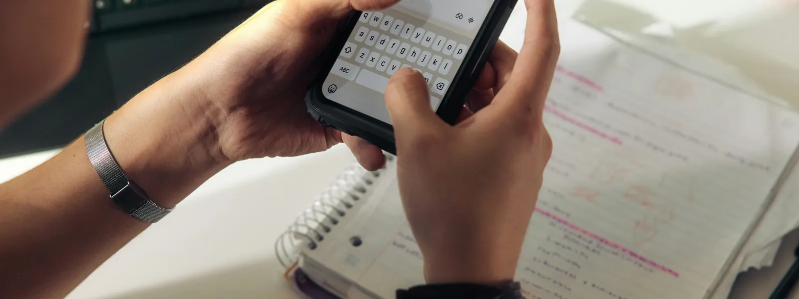 Phone and notebook on a desk representing email planning and scheduling